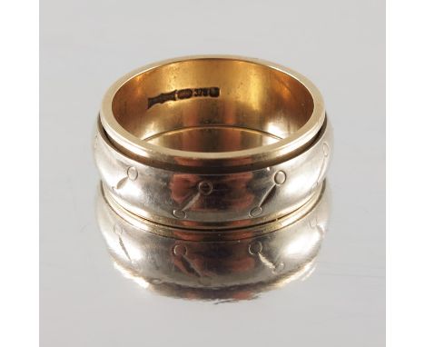 A 9 carat gold and white metal ring, central revolving band engraved with diagonal mitre and ball motifs, approx. size K, 5.6