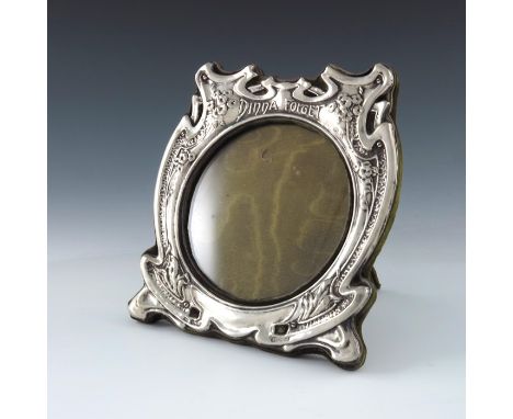 An Arts and Crafts silver photo frame, J Aitkin and Son, Birmingham 1901, the circular aperture within a shield form frame, e