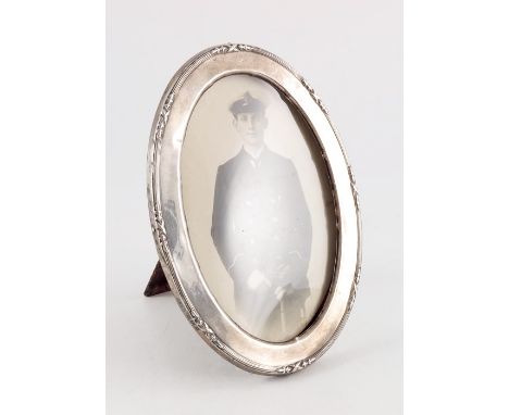 A George V silver photo frame, Cornelius Sauders and Frank Shepherd, Birmingham 1915, oval form with ribbon and reed border, 