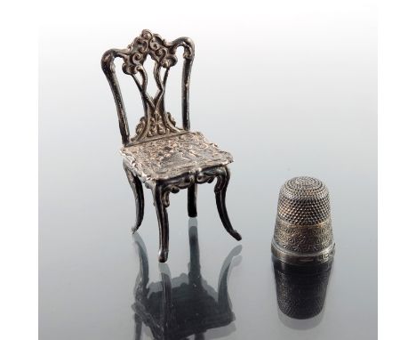 An Elizabeth II silver miniature chair and an Edwardian silver thimble, MK(J), Birmingham 1970 and 1902, 6cm high, 0.42ozt (2