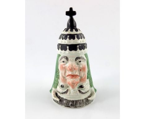 A Staffordshire novelty anticatholic stirrup cup, circa 1815, modelled as a mitred pope, inverted to form a horned devils mas
