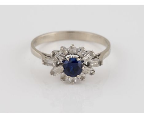 RING Weißgold. Ringmaß ca. 55, Ges.-Gew. ca. 2,6 g. Geprüft 18 K. Ein rund facettierter Saphir (wohl synth.), etwa 0,4 ct. 12
