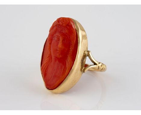 RING Gelbgold. Ringmaß ca. 57, Ges.-Gew. ca. 6,3 g. Geprüft 14 K. Ringkopf mit geschnittenem Damenportrait, wohl Koralle. Bit