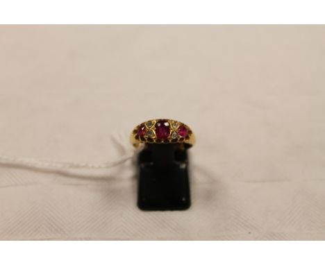 An 18ct gold three stone ruby and diamond ring. CONDITION REPORT: Good condition.