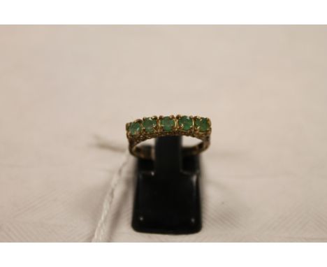 A 9ct gold emerald half hoop ring. CONDITION REPORT: Good condition.