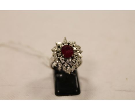 An 18ct white gold ruby and diamond cluster ring. CONDITION REPORT: Good condition. Set with thirty diamonds.