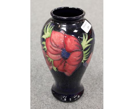 A Moorcroft tall vase decorated with amaryllis design, height 26 cm. CONDITION REPORT: Good condition, the item is a second.