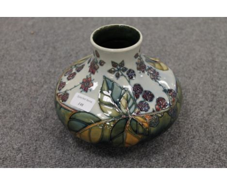 A Moorcroft pottery squat vase decorated with leaf and berries, height 16.5 cm. CONDITION REPORT: Good condition, the item is