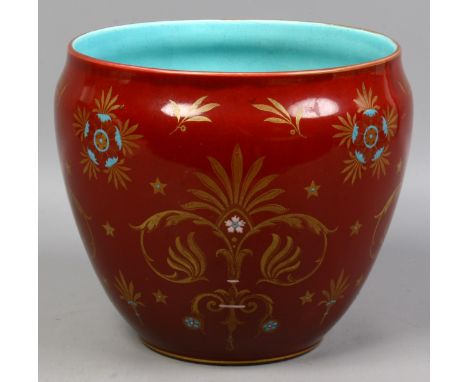 A Sarreguemines jardiniere with claret glaze and gilt decoration. 