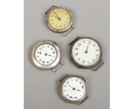 Four silver watch heads with wire lugs, two with enamel dials (AF).