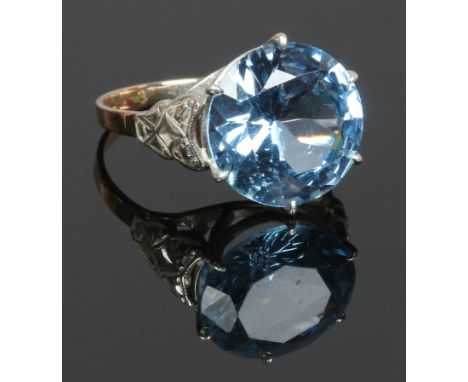 A gold and silver cocktail ring set with a large blue stone, size m.