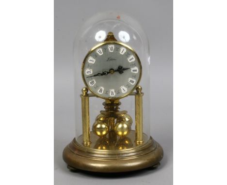 A brass Kern West German Torsion clock under glass dome.