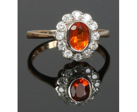 A 9 carat gold 12 stone diamond ring set with a fire opal, size N.