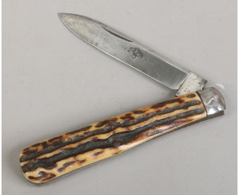 A folding steel cock knife with stag antler scales.