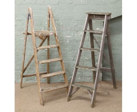 Two pairs of wooden step ladders.