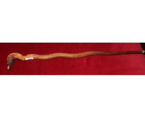 A carved walking stick of dragon form.