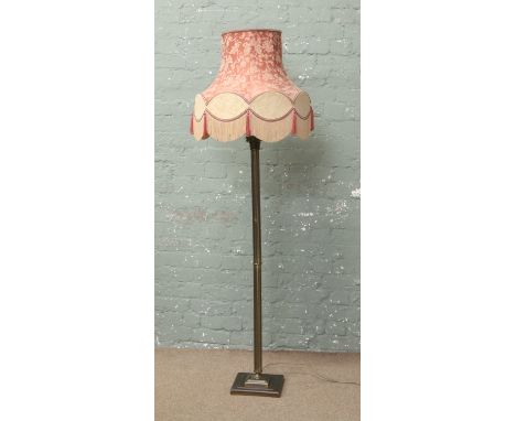 A brushed brass effect standard lamp with reeded column and floral shade.