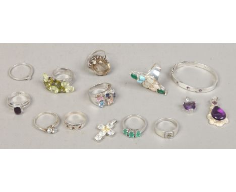 Ten silver dress rings, a silver gem set babies bangle and three gem set pendants.