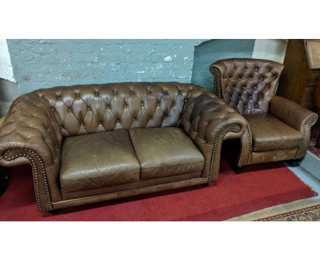 A brown deep button leather Chesterfield style sofa and matching arm chair.