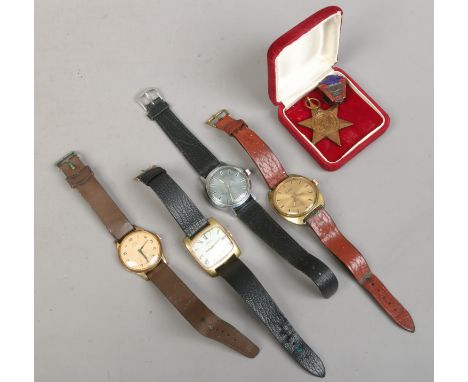 Four gents manual wristwatches along with a World War II 1939-45 star and a silver badge.