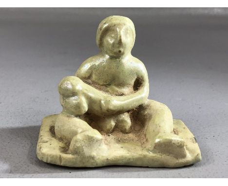 Ceramic figure of a seated man with large phallus, remnants of pale green glaze, approx 7cm wide at base and 6cm in height