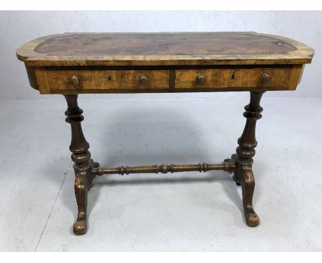 Victorian walnut writing table with leather inset top on two turned columns on four outswept supports,  with two drawers and 