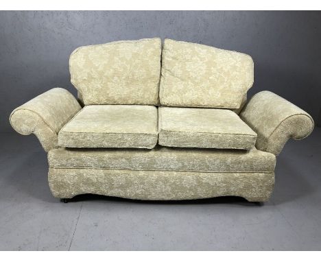 Cream upholstered drop arm two seater sofa on castors