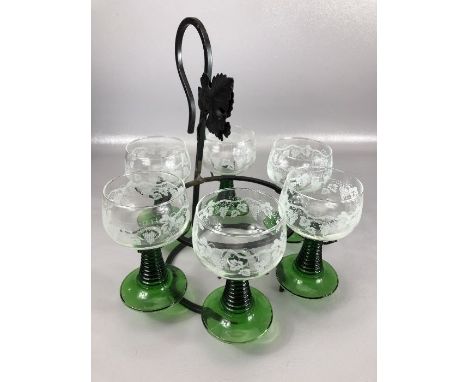 Set of six vintage wine glasses with green stems and etched grape design suspended on metal stand