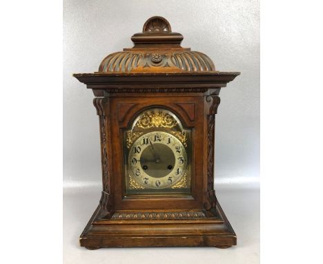 Continental oak cased mantel clock, brass dial with  Arabic numerals, the brass movement stamped Junghens, approx 50cm tall (