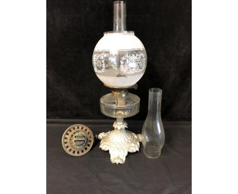 A silver painted metal mounted oil lamp, acid etched glass globe and chimney; a spare reservoir and a spare chimney (5) 