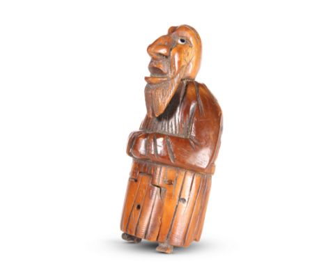 A CARVED COQUILLA NUT FIGURAL SNUFF BOX, CIRCA 1840,&nbsp;carved as a caricature of a bearded man, the tails of his coat open
