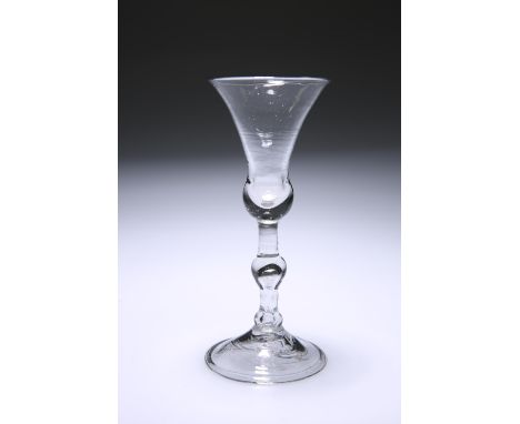 A LIGHT BALUSTER WINE GLASSCirca 1730With bell bowl on a knopped tear-drop stem, raised on a domed folded foot.16.3cm.The abs