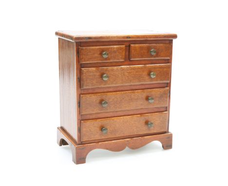 A 19TH CENTURY MAHOGANY MINIATURE CHEST OF DRAWERSWith two short over three long graduated drawers, each with brass pull, rai