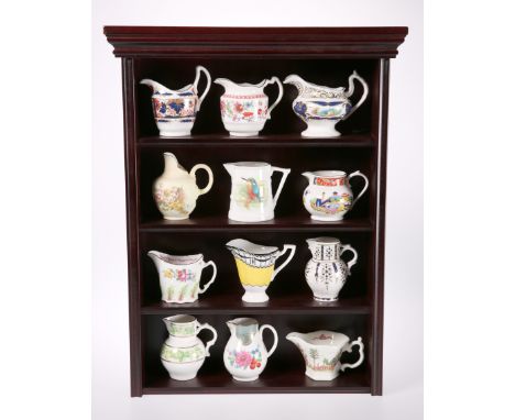 A SET OF TWELVE ROYAL WORCESTER "HISTORICAL COLLECTION" JUGS, on a mahogany effect wall-hanging display shelf. Shelf 53cm hig