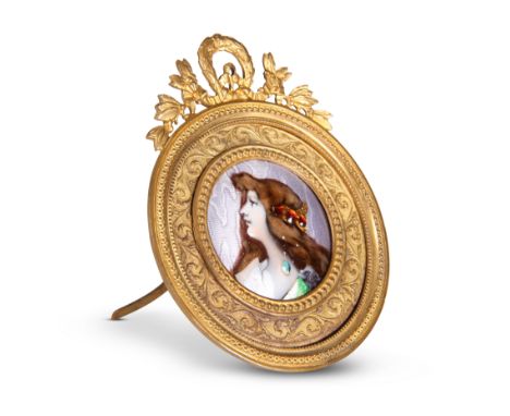 A LIMOGES ENAMEL PLAQUE, CIRCA 1900, painted with a portrait of "Anette" after Grasset, in a gilt-metal circular frame with r