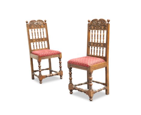 A PAIR OF CARVED OAK BACKSTOOLS, the carved backs with C-scroll crest and turned spindles, raised on bobbin turned legs and s