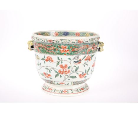 A CHINESE FAMILLE VERTE PLANTER, circular with mask handles (lacking rings), enamel painted with birds, insects and foliage. 