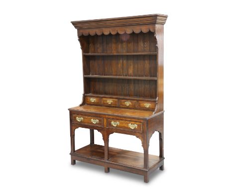 A SMALL OAK DRESSER AND RACK, IN GEORGIAN STYLE, the boarded rack with penny carved apron above two shelves over four spice d