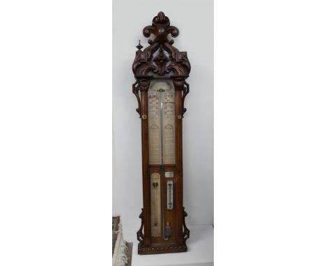 An oak framed "Admiral Fitzroy's barometer", with a leaf carved cresting, fluted pillasters and plinth base with egg and dart