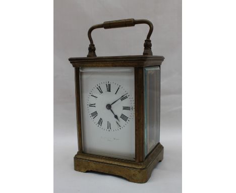 A brass cased carriage timepiece, the enamel dial with Roman numerals with a lever platform escapement, with a key, 16cm high