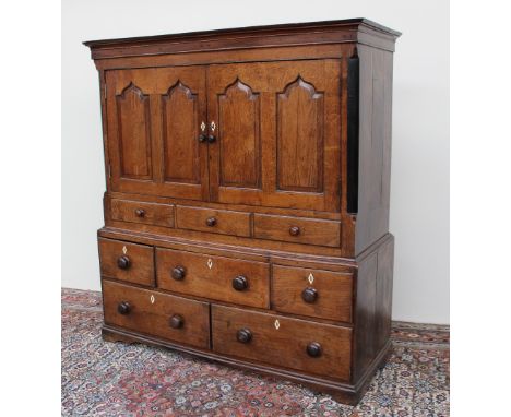 An 18th century oak mule chest, the moulded cornice above a pair of ogee panelled doors and three dummy drawers, the base wit