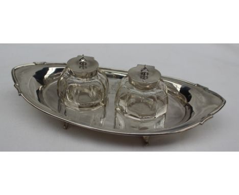 A George V silver desk inkwell, of pointed oval form set with two silver topped and glass inkwell, bears a crest for "Singapo