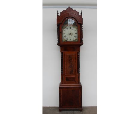 A 19th century mahogany longcase clock, the arched hood with turned and carved columns above a short trunk door carved column