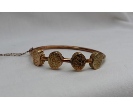 A 19th century yellow metal momento mori tubular hinged bangle, set with four floral engraved oval lockets each separately en