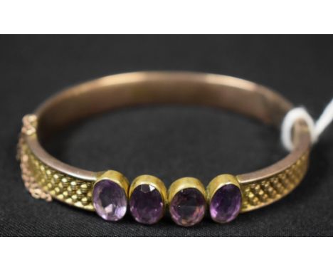 A silver gilt hinged bangle set with four faceted oval amethysts, unmarked, late 19th century