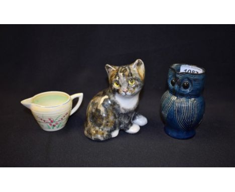 A Brannam Barnstaple owl jug; a Clarice Cliff cream jug; a Winstanley kitten (3)