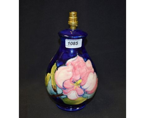 A Moorcroft Magnolia pattern baluster table lamp, applied with large pink flowers and slender leafy branches on a cobalt blue