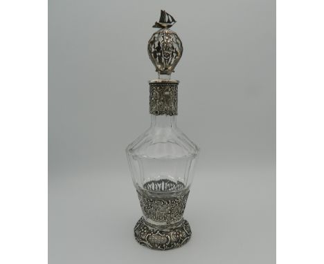 A Continental silver and cut glass decanter and stopper, the silver applied with figures, the stopper with a ship finial, var