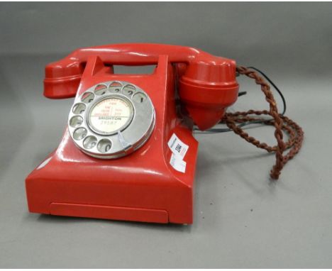 A vintage red telephone. 23 cm wide.