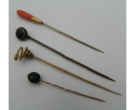 Four boxed stick pins, including gold examples